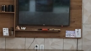 En möbel i trä som används för underhållning, med en platt-TV, en hylla med dekorativa föremål och en skylt som visar att husdjur är välkomna.