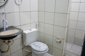 A bathroom with a sink, toilet, and a toilet paper holder on the wall. - Cozy house in the center of Maragogi, pets allowed. (Maragogi)