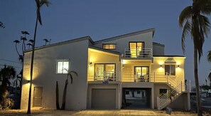 Una casa moderna de dos pisos con garaje, un balcón y una escalera que conduce al nivel superior.