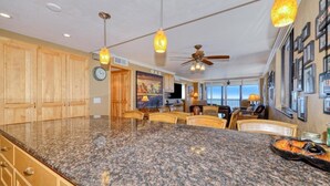 Eine geräumige Küche mit Granit-Arbeitsplatten, Holzschränken und einem Essbereich mit einer großen Kochinsel.