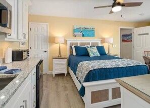 A bedroom with a bed, bedside tables, a nightstand, a ceiling fan, and a painting on the wall. - Casa Bella D in Fort Myers Beach (Fort Myers Beach)