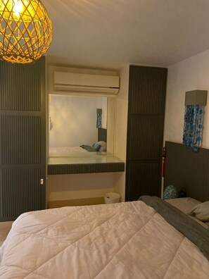 Ein Schlafzimmer mit Etagenbett, Pendelleuchte, Spiegel und Wanddekoration.