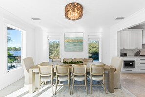 A dining room with a large table, six chairs, and a hanging light fixture. - Lakefront with Pool and Gulf Views (Santa Rosa Beach)