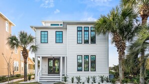 A two-story house with a front porch, a garage, and a well-maintained lawn. - Lakefront with Pool and Gulf Views (Santa Rosa Beach)