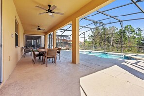 Eine Terrassenanlage im Freien mit Pool, überdachter Lounge-Ecke und Deckenventilatoren.