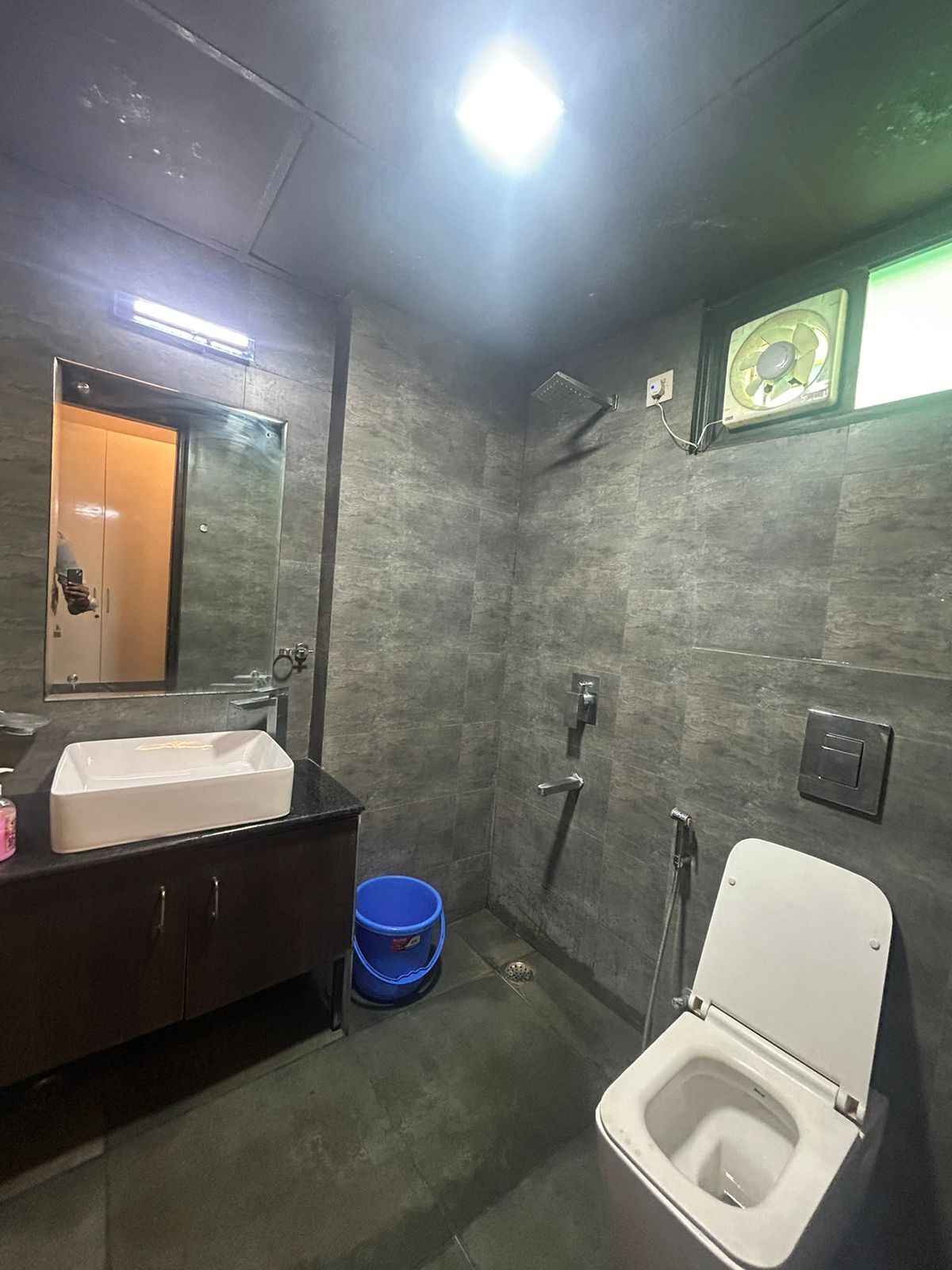Une salle de bain moderne équipée de toilettes, d’un lavabo et d’une douche.