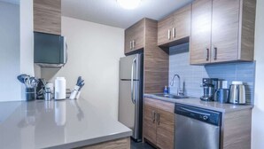 Una cocina moderna con armarios de madera, electrodomésticos de acero inoxidable y lavavajillas.