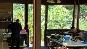 A kitchen with a stone wall, a sink, and a window overlooking a garden.