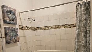 Un bany amb banyera, vàter, rentapel i una cortina de bany.