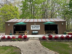 A rustic wooden building with two open garage doors, a bench, and a sign reading "Wonder Woods".