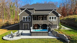 A two-story house with a covered outdoor swimming pool, a deck, and a fenced yard. - Luxe Retreat w/ Spa Sleeps 25 Designed For Groups (Charlotte)
