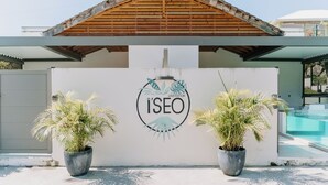 A modern building with a wooden roof, a white facade, and a logo that reads "I'SEO HABITATION". - Habitation I'SEO Adult Only (Sainte-Anne)