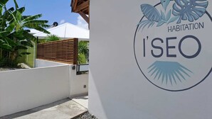 A building with a logo that reads 'HABITATION I'SEO' and a wooden slatted fence. - Habitation I'SEO Adult Only (Sainte-Anne)