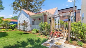 A house with a porch, a bicycle, and a garden. - Charming Cottage in Downtown Charleston (Charleston)