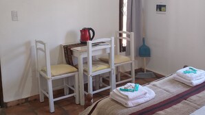A room with a bed, two chairs, a table, an air conditioner, a TV, a window with curtains, and a broom. - Abril (Cafayate)