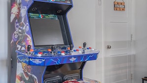 A video game arcade machine with NFL branding, a control panel with buttons and joysticks, and a door with a 'Gym Room' sign.