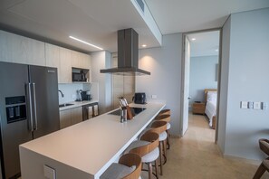 A modern kitchen with a central island, stainless steel appliances, and wooden bar stools. - Calablanca T4-404 in Cartagena de Indias (Cartagena)