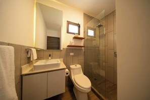 Ein modernes Badezimmer mit Toilette, Waschbecken und Dusche.