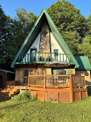 A lodge with a stone chimney, a balcony with a railing, and a number '7136' on the building.