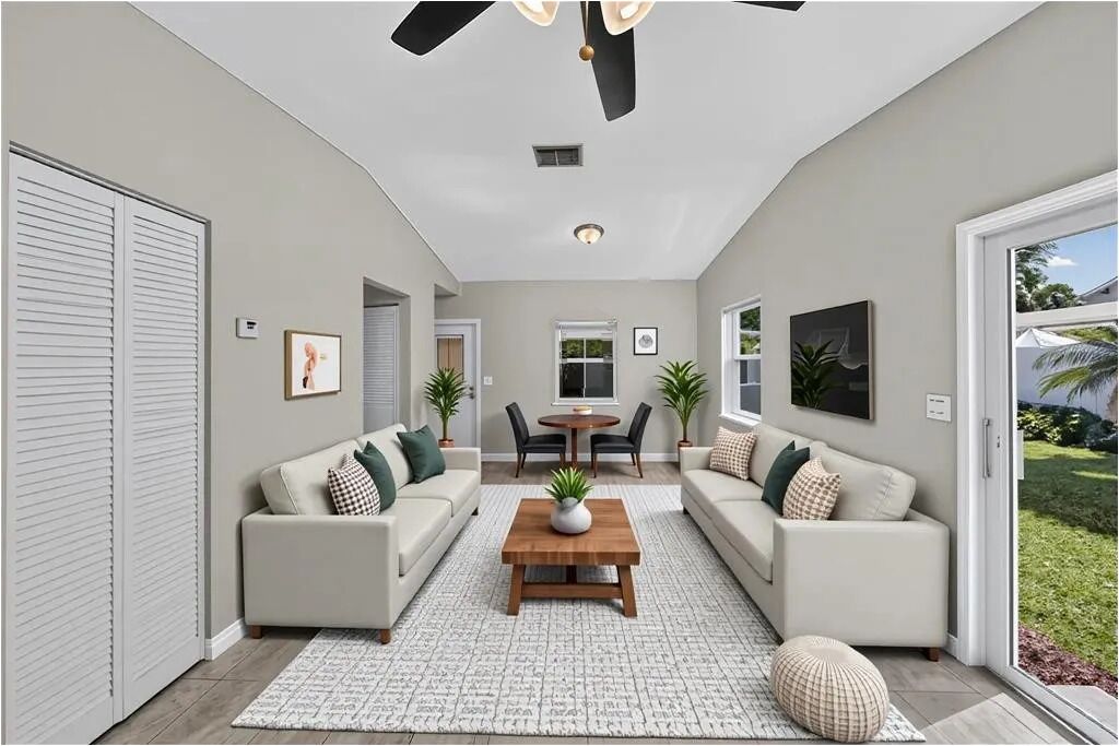A modern living room with two sofas, a coffee table, and a dining table with chairs.
