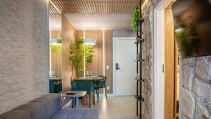 Un interior moderno con una zona de estar, una mesa de comedor y un jardín vertical.