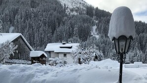 Un paysage enneigé avec un lampadaire et des bâtiments en arrière-plan.