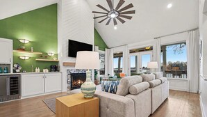 A modern living room with a fireplace, a sofa, and a television. - New! Lakefront-Sleeps 14-Hot Tub-Putting Green (Denver)