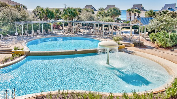 Ein Schwimmbecken mit Liegestühlen und einem Wasserspiel.