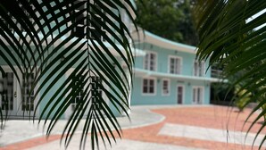 A building with a curved facade and a paved courtyard. - Torraille Waterfall Villas - Unit 1 (Soufrière)