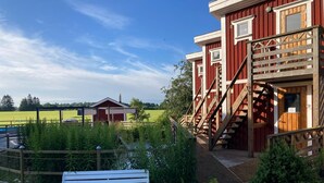 Een rood gebouw met een houten trap en een witte bank ervoor.
