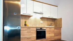 A kitchen with wooden cabinets, a stainless steel refrigerator, an oven, and a sink. - Amazing apartment in Vrsi with WiFi (Vrsi)