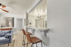 A modern kitchen with a white countertop, a built-in oven, and a hanging light fixture. - Emma's:King Beds/2 Miles to Campus (4BR) (Bryan)