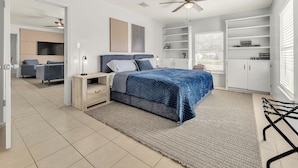 Ein modernes Schlafzimmer mit Bett, Nachttischen, Deckenventilator und integrierten Regalen.
