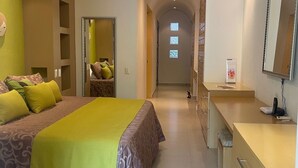 Ein Hotelzimmer mit Bett, Schminktisch mit Spiegel, Deckenventilator und Klimaanlage.