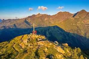 A mountain peak with a cross, rocky terrain, and a clear sky. - Appartement Borealis (Sankt Gallenkirch)