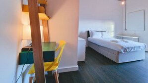 Une chambre à coucher moderne avec un lit, des tables de chevet et un bureau avec une chaise.
