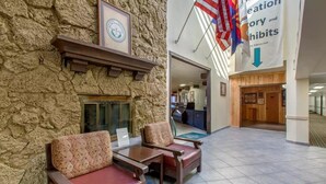 A lobby with stone walls, a reception desk, and a sign for the Creation Gallery and Exhibits. -  Scenic View Inn - Lake Powell - Page AZ (Page)