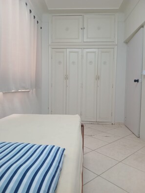 A bedroom with a bed, a wardrobe, and a door.