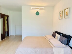 A bedroom with a bed, pillows, a wall clock, and framed pictures. - Casa Buda Maggiore 2 Bedrooms - MXP, Lakes & Leonardo (Sesto Calende)