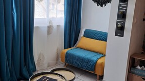 A modern living room with a sofa, a coffee table, and a wall-mounted plant shelf. - A little cocoon in the heart of Cantal (Arpajon-sur-Cère)