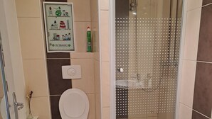 Un baño con inodoro, ducha y lavamanos.