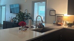 A modern kitchen with a central island, a built-in dishwasher, and a window with blinds. - Perfect 2-bedroom apartment in Oxford, MS.  ONLY ONE MILE FROM THE SQUARE (Oxford)