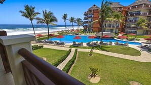 A resort with a pool, palm trees, and ocean views. - Ocean Front - Two Bedroom Vivo Resorts (Bajos de Chila)