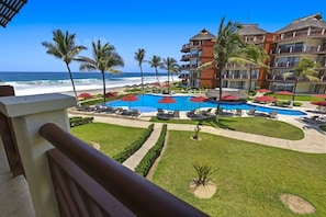 Un resort con piscina, palmeras y vistas al océano.