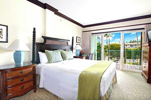 Quarto de hotel com uma cama grande, duas mesas de cabeceira, uma cômoda e uma varanda com vista para o verde.