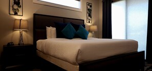 A neatly made bed with a headboard, two bedside lamps, and a nightstand with a clock. - D1 and D4 Combo Unit - Sage Creek Resort Moab (Moab)