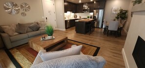 Ein modernes Wohnzimmer mit einer Couch, einem Couchtisch und einem Essbereich mit Stühlen.