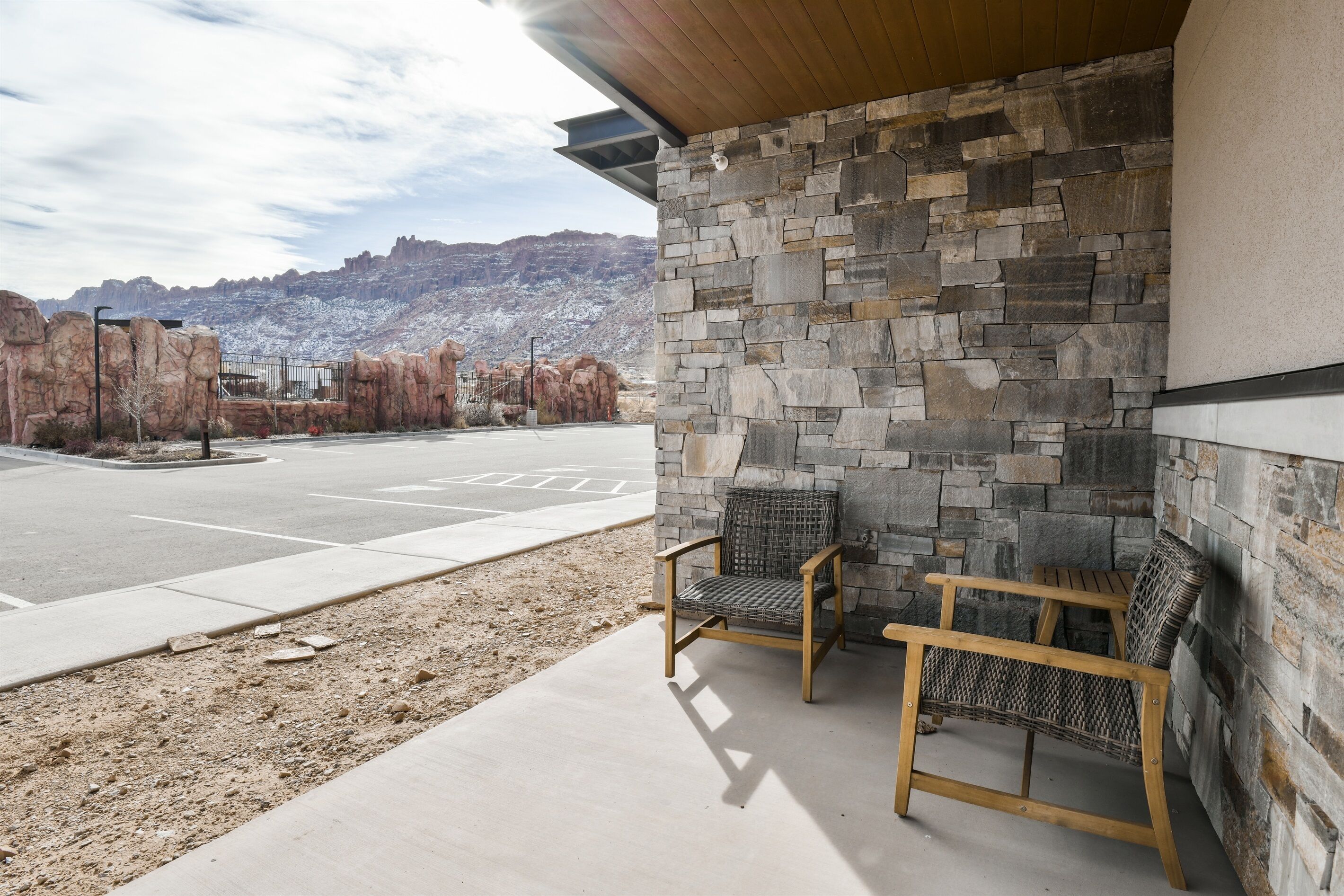 A covered outdoor seating area with stone walls and a view of a mountainous landscape.