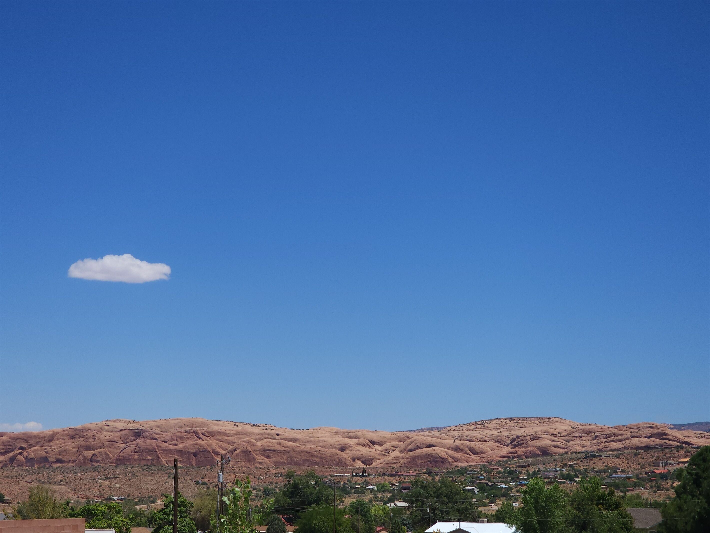 A mountainous landscape with a clear sky and a small cloud.