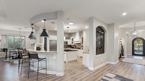 A spacious kitchen with a central island, pendant lighting, and a welcoming sign. - Weekday deals Pool King Bed Giant games Single level Space Firepit Min DT Austin (Austin)